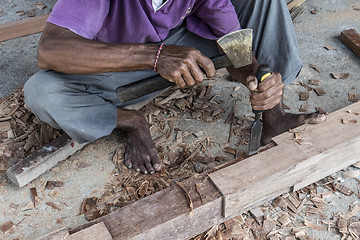 Image showing Close up of warn hands of carpenter working in traditional manual carpentry shop in a third world country.