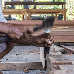 Image showing Close up of warn hands of carpenter working in traditional manual carpentry shop in a third world country.