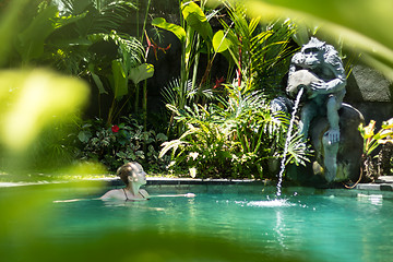 Image showing Sensual young woman relaxing in outdoor spa infinity swimming pool surrounded with lush tropical greenery of Ubud, Bali.