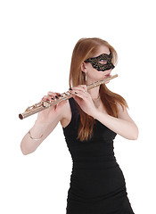 Image showing Woman standing and playing the flute with a mask