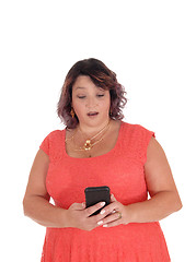 Image showing Woman looking surprised at her cell phone