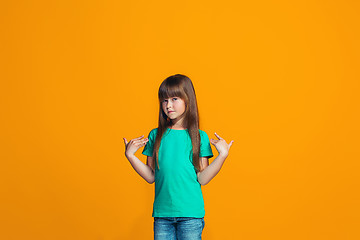 Image showing The happy teen girl standing and smiling against pink background.