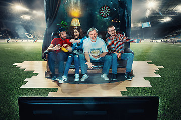 Image showing Soccer football fans sitting on the sofa and watching TV in the 