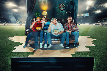 Image showing Soccer football fans sitting on the sofa and watching TV in the 