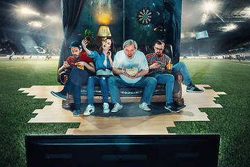 Image showing Soccer football fans sitting on the sofa and watching TV in the 