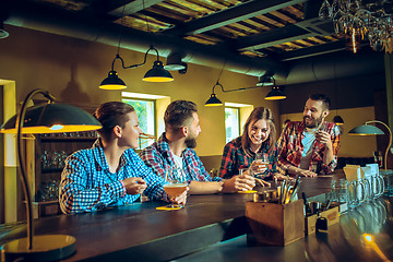 Image showing Sport, people, leisure, friendship and entertainment concept - happy football fans or male friends drinking beer and celebrating victory at bar or pub