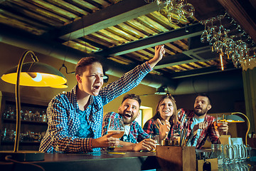 Image showing Sport, people, leisure, friendship and entertainment concept - happy football fans or male friends drinking beer and celebrating victory at bar or pub