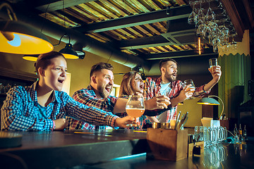 Image showing Sport, people, leisure, friendship and entertainment concept - happy football fans or male friends drinking beer and celebrating victory at bar or pub