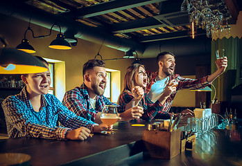 Image showing Sport, people, leisure, friendship and entertainment concept - happy football fans or male friends drinking beer and celebrating victory at bar or pub