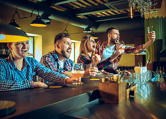 Image showing Sport, people, leisure, friendship and entertainment concept - happy football fans or male friends drinking beer and celebrating victory at bar or pub