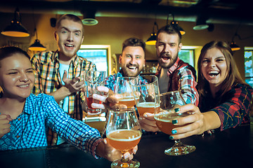 Image showing Sport, people, leisure, friendship and entertainment concept - happy football fans or male friends drinking beer and celebrating victory at bar or pub