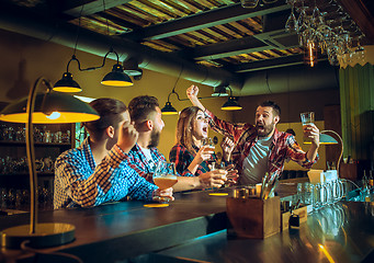 Image showing Sport, people, leisure, friendship and entertainment concept - happy football fans or male friends drinking beer and celebrating victory at bar or pub