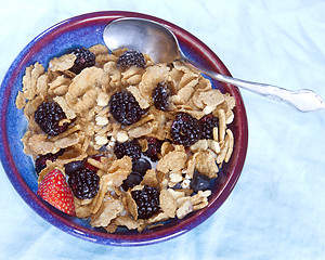 Image showing raisin bran breakfast cereal with blackberries blueberries straw