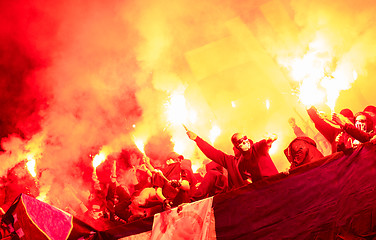 Image showing football hooligans with mask holding torches in fire