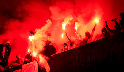 Image showing football hooligans with mask holding torches in fire