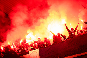 Image showing football hooligans with mask holding torches in fire