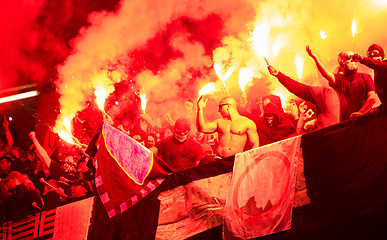 Image showing football hooligans with mask holding torches in fire