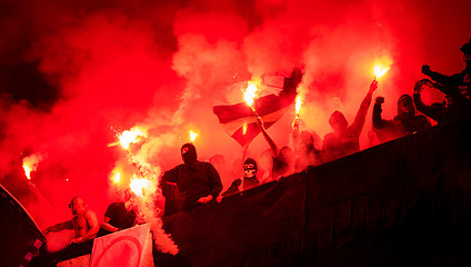 Image showing football hooligans with mask holding torches in fire