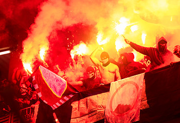 Image showing football hooligans with mask holding torches in fire