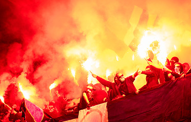 Image showing football hooligans with mask holding torches in fire