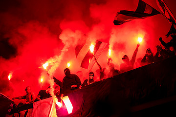 Image showing football hooligans with mask holding torches in fire