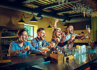 Image showing Sport, people, leisure, friendship and entertainment concept - happy football fans or male friends drinking beer and celebrating victory at bar or pub