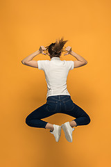 Image showing Closeup of young woman\'s body in empty white t-shirt on orange background. Mock up for disign concept