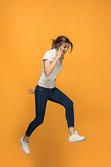 Image showing Full length of pretty young woman with mobile phone while jumping