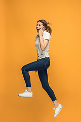 Image showing Full length of pretty young woman with mobile phone while jumping