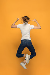 Image showing Closeup of young woman\'s body in empty white t-shirt on orange background. Mock up for disign concept