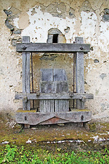 Image showing Old Antique wooden wine press in front of the rusty wall