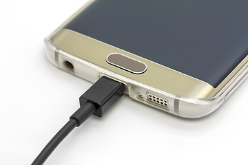 Image showing Mobile smart phone charging on a white background