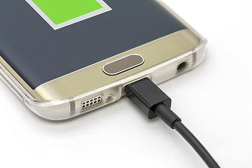 Image showing Mobile smart phone charging on a white background