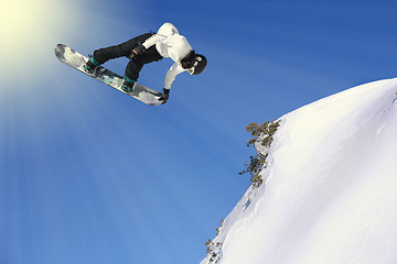 Image showing Snowboarding Snowboard Snowboarder at jump mountains at sunny da