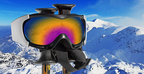 Image showing Close up of the ski goggles through which it is seen snowed moun