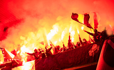 Image showing football hooligans with mask holding torches in fire