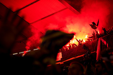 Image showing football hooligans with mask holding torches in fire