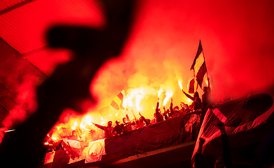 Image showing football hooligans with mask holding torches in fire