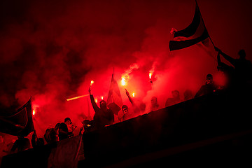 Image showing football hooligans with mask holding torches in fire
