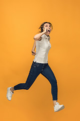 Image showing Full length of pretty young woman with mobile phone while jumping