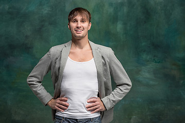 Image showing The happy man standing and smiling against studio background.