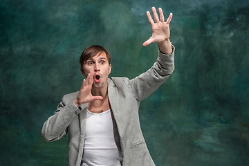 Image showing Isolated on pink young casual man shouting at studio