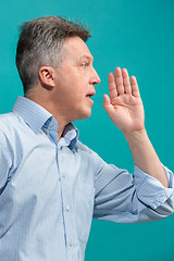 Image showing Isolated on pink casual man shouting at studio