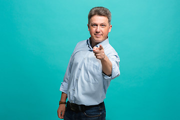 Image showing The happy business man point you and want you, half length closeup portrait on blue background.