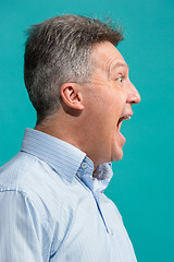 Image showing The emotional angry man screaming on blue studio background