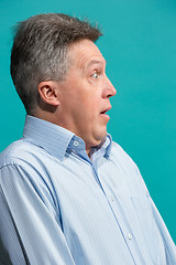 Image showing The attractive man looking suprised isolated on blue