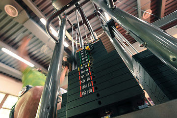 Image showing Motion blurred unrecognizable person doing upper traction gym machine