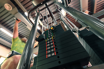 Image showing Motion blurred unrecognizable person doing upper traction gym machine