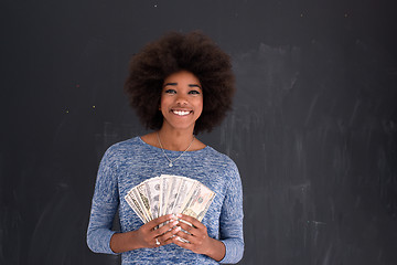 Image showing black woman holding money on gray background