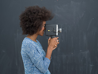 Image showing african american woman using a retro video camera